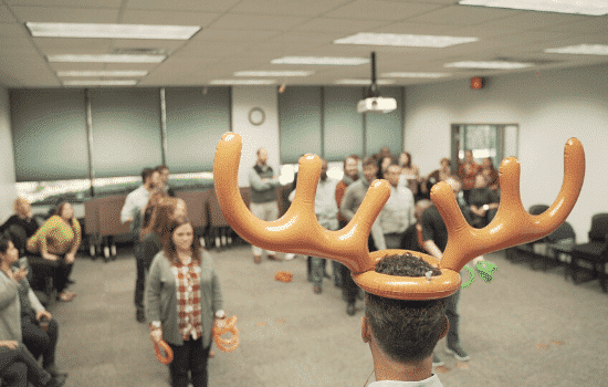 Ken wearing inflatable antlers while Katie prepares to toss rings at him