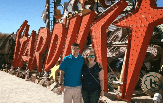 Hilary Cyr and husband by neon sign in Las Vegas