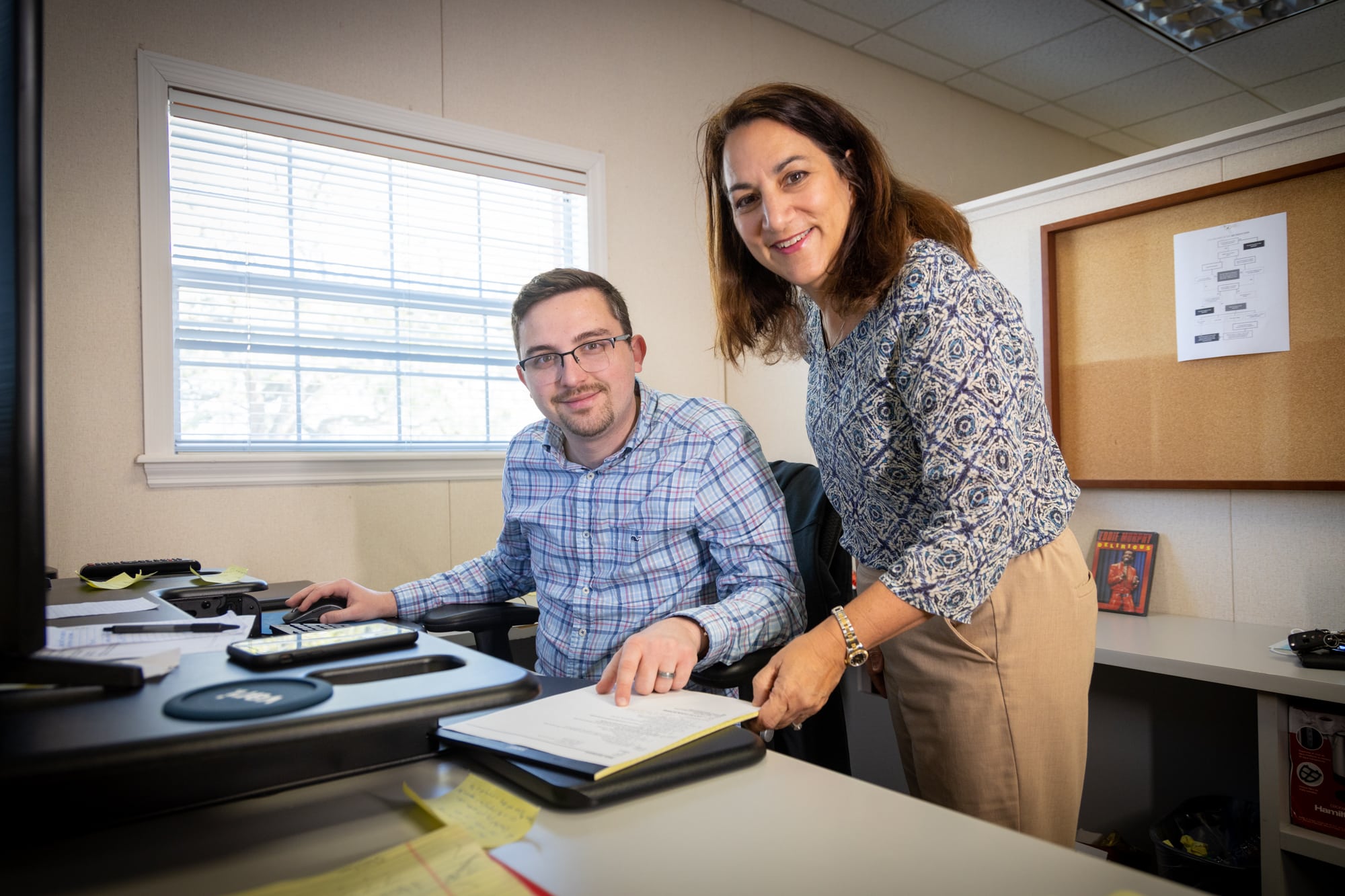 Two James Moore team members sitting behind a desk training.