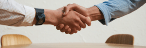 handshake showing business casual clothing and boardroom table