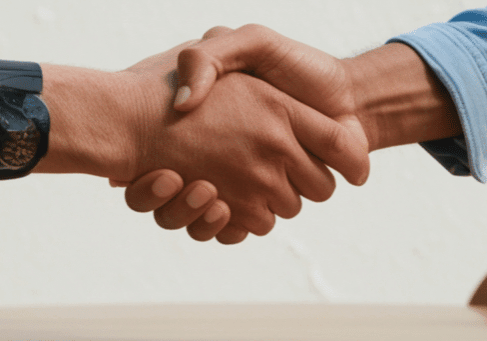 handshake showing business casual clothing and boardroom table