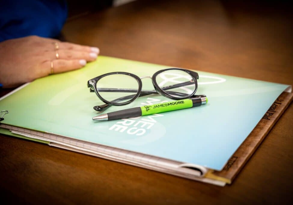 Daytona JMCO Stock Photos A pair of black eye glasses sitting on top of a James Moore branded folder.