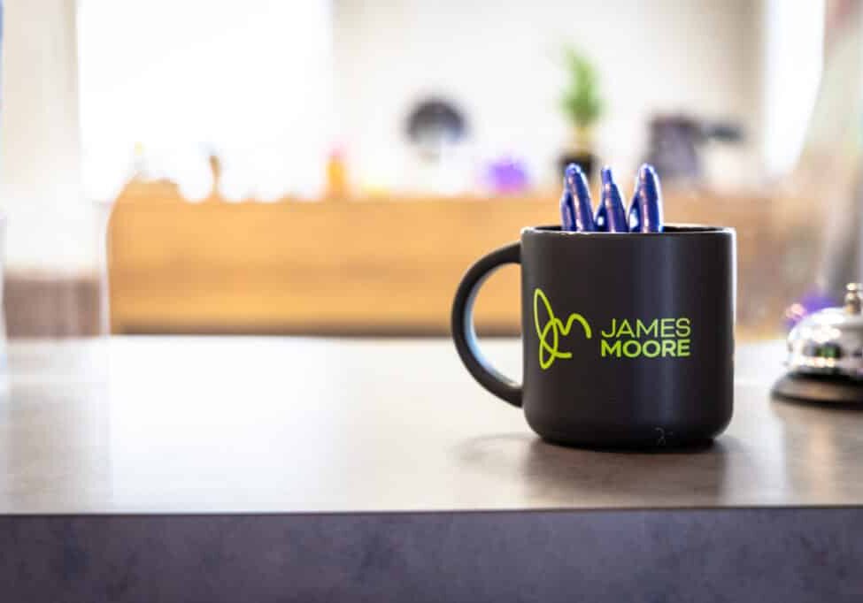 DeLand JMCO Stock Photos Coffee cup sitting on a counter top with three blue pens in it.